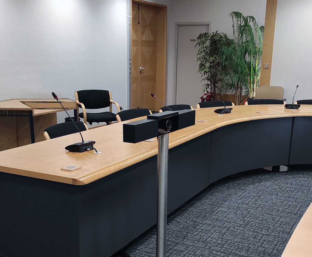 Salle de réunion avec barre de visioconférence au centre